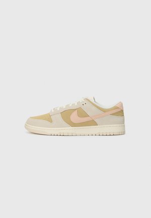 Baskets Nike en suède beige et rose, avec une tige texturée, des lacets blancs et une semelle épaisse crème à motif antidérapant.