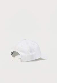 Λευκό καπέλο του μπέιζμπολ από βαμβάκι, με ρυθμιζόμενο λουράκι στο πίσω μέρος και οπές αερισμού στην κορυφή. Λεπτή υφή.