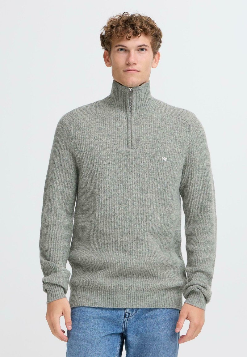 Maglione grigio a maglia con colletto alto e design a mezza zip. Presenta una texture a coste e un piccolo logo sul petto. Vestibilità casual.
