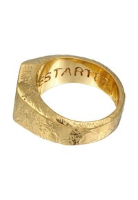 Bague en or avec un extérieur texturé et une forme carrée. Intérieur gravé avec "STARTER." Fini réfléchissant et surface mate inégale.