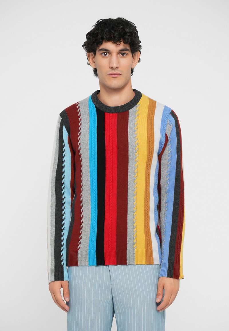 Multicolored knitted sweater featuring vertical stripes in blue, red, yellow, gray, and brown, with textured cable patterns and a crew neck.