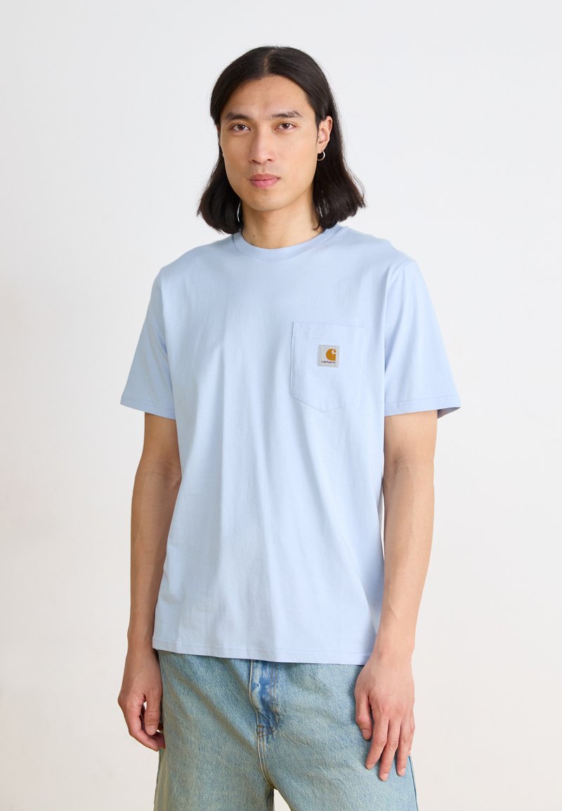 Light blue cotton t-shirt with short sleeves, round neckline, and a chest pocket featuring a small logo patch. Casual fit.