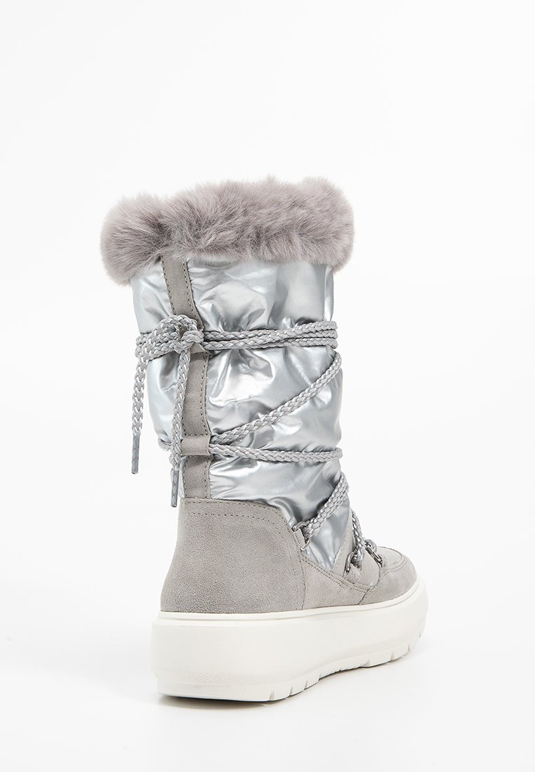 Silberne, puffige Stiefel mit grauen Wildleder-Akzenten, einem Fellrand oben und geflochtenen Schnürsenkeln. Sie haben eine dicke weiße Gummisohle.