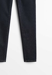 Granatowe dżinsy, slim fit, o gładkiej fakturze, prostym kroju nogawki oraz kontrastującym żółtym przeszyciu wzdłuż szwów.