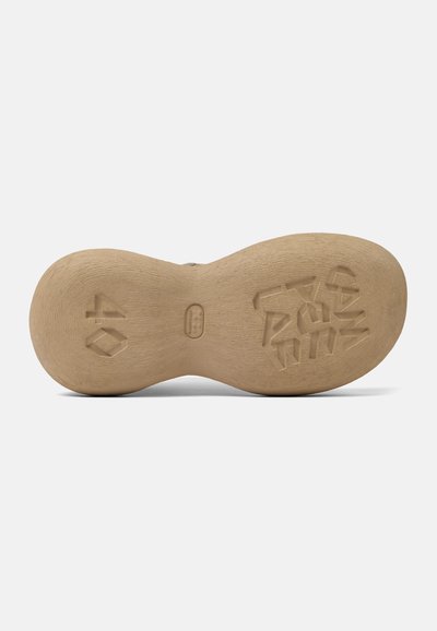Skosula i ljusbeige gummi, med en intrikat strukturerad design och ingraverad storlek '40' tillsammans med geometriska mönster.