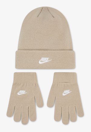 Cappello invernale Nike beige lavorato a maglia e guanti coordinati, entrambi con ricamo del logo Nike bianco, esposti su sfondo bianco.