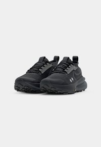 Black running shoes with textured fabric upper, reflective silver accents, cushioned sole, and rugged black outsole for traction.