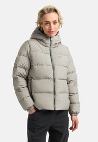 Giacca invernale imbottita di colore grigio chiaro con cappuccio, zip frontale, polsini elasticizzati e tasche laterali. Presenta una texture trapuntata e un dettaglio con logo.