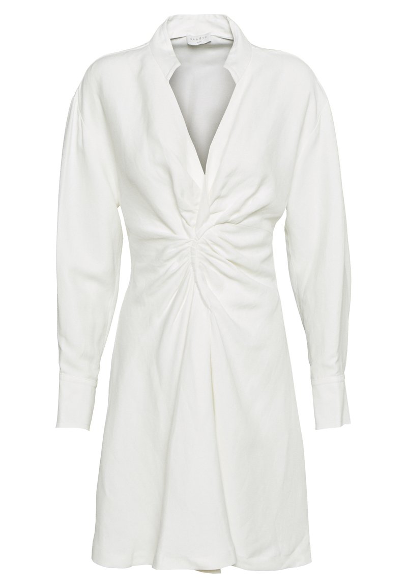 Vit långärmad klänning med djup V-ringning, draperad detalj vid midjan och en något utsvängd kjol.