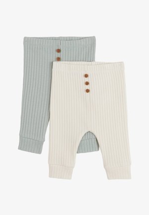Deux paires de pantalons côtelés : une en vert doux avec trois boutons marron, l'autre en crème avec des boutons similaires et une découpe sur la jambe.