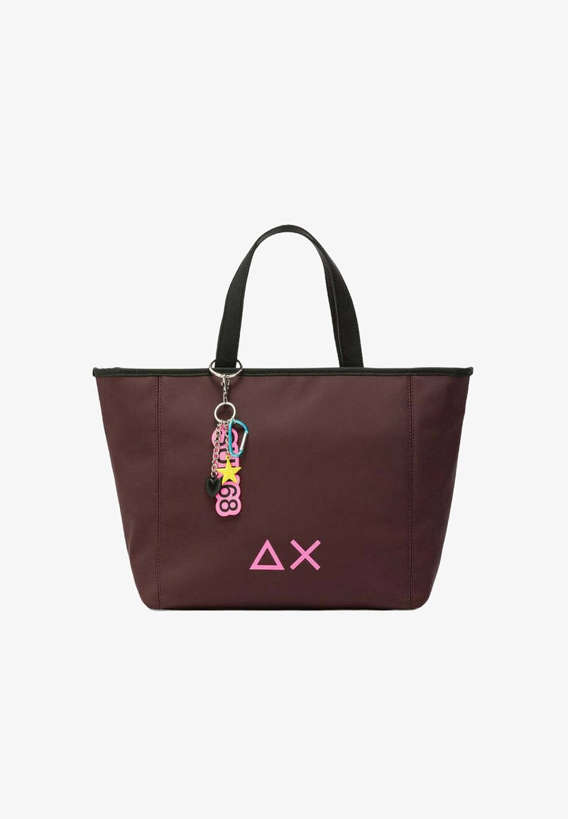 Donker bordeauxrode tote bag van stof, met zwarte handvatten, een roze logo en een kleurrijke sleutelhanger met sterren en harten.
