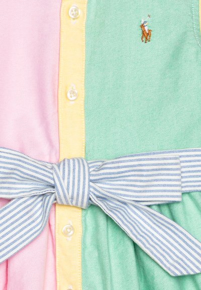 Colorful dress featuring pastel pink, yellow, and green sections. White buttons and a blue striped bow create notable accents.