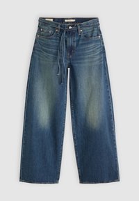 Jean denim bleu à jambes larges avec des zones décolorées aux cuisses, cinq poches, passants de ceinture, bouton métal, braguette zippée et une ceinture en tissu nouée à la taille.