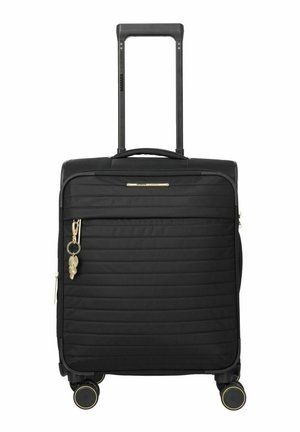 Valise noire en coque souple avec poignée télescopique, quatre roulettes pivotantes, poche avant zippée et un porte-clés doré accroché au tirette de la fermeture éclair.