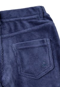 Pantaloni in corduroy blu scuro con tessuto testurizzato, dotati di una tasca posteriore e di un dettaglio logo ricamato sulla tasca.