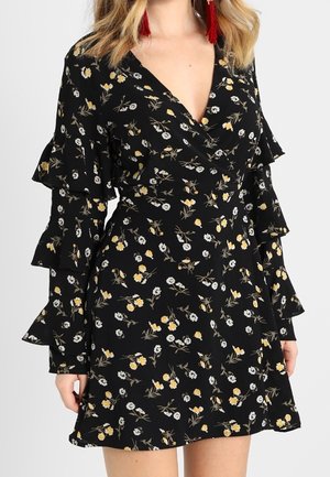 Černé květované zavinovací šaty se žlutými a bílými květy, s vrstvenými dlouhými rukávy s volánky a výstřihem do V.