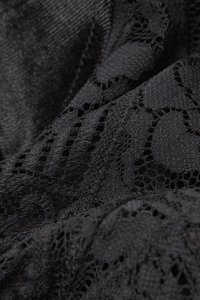 Svart spets med intrikata blommönster, som kombinerar öppna vävningar och solida texturer, mjuk och något genomskinlig.