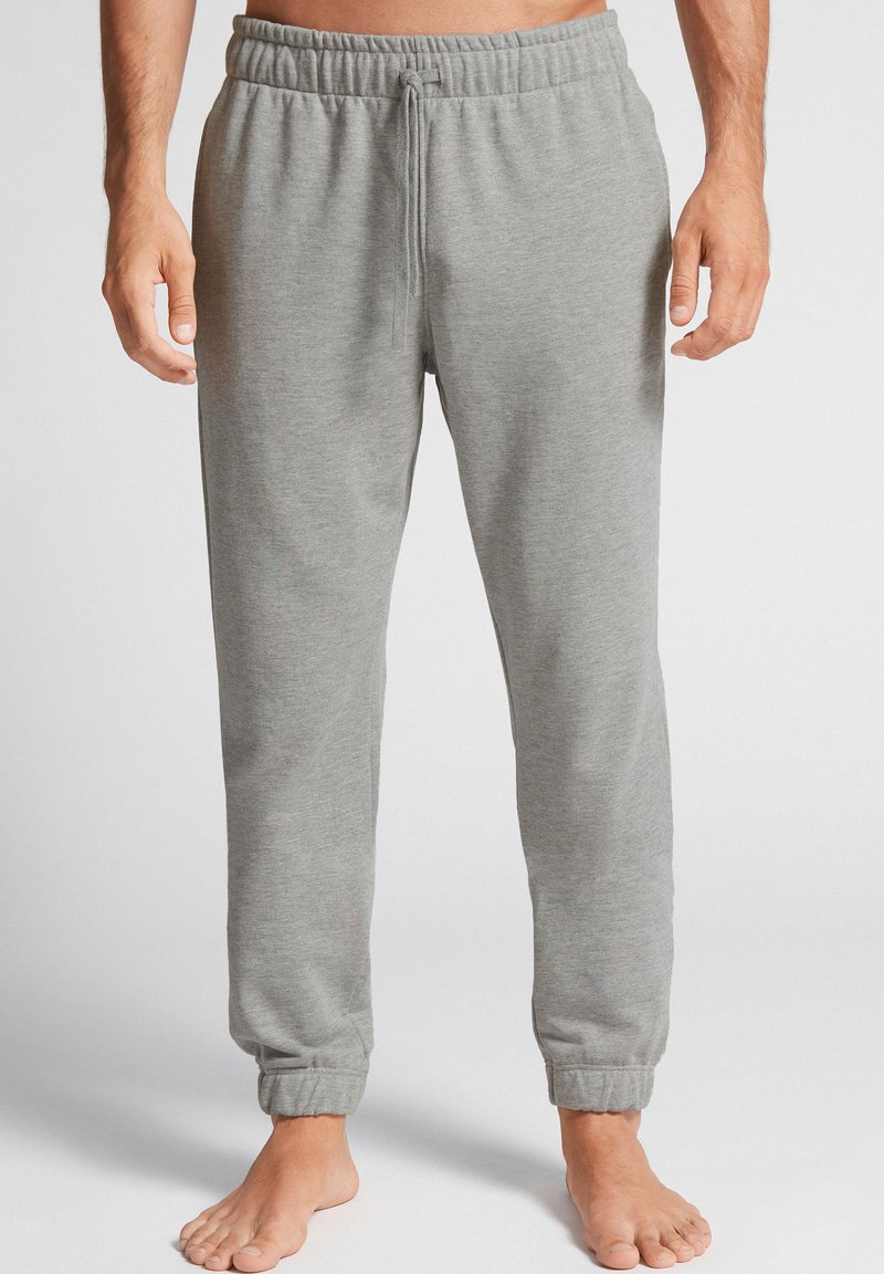 Grijze sweatpants met een elastische tailleband, verstelbaar trekkoord en aansluitende boorden. Gemaakt van zachte stof met een gladde textuur.