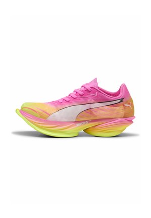 Chaussure de course rose vif et jaune avec une semelle épaisse et sculptée et un logo Puma blanc sur le côté.