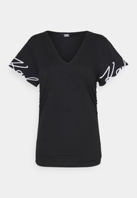 Musta V-pääntie T-paita lyhyillä hihoilla, jossa on valkoinen logoelementti hihoissa, rypytetty sivuosa, valmistettu pehmeästä ja kevyestä kankaasta.