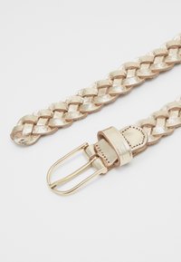 Woven zlatni metalni remen s glatkom završnom obradom, s zlatnom metalnom kopčom i odgovarajućim kožnim trakama za učvršćivanje.