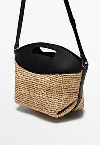 Borsa a spalla in paglia intrecciata con parte superiore in pelle nera, dotata di manico a ragguaglio e tracolla regolabile. Superficie testurizzata con forma rettangolare.