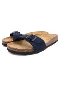 Sandales en daim bleu marine avec deux larges sangles et une boucle noire, présentant un coussin en liège moulé et une semelle extérieure en caoutchouc texturé.