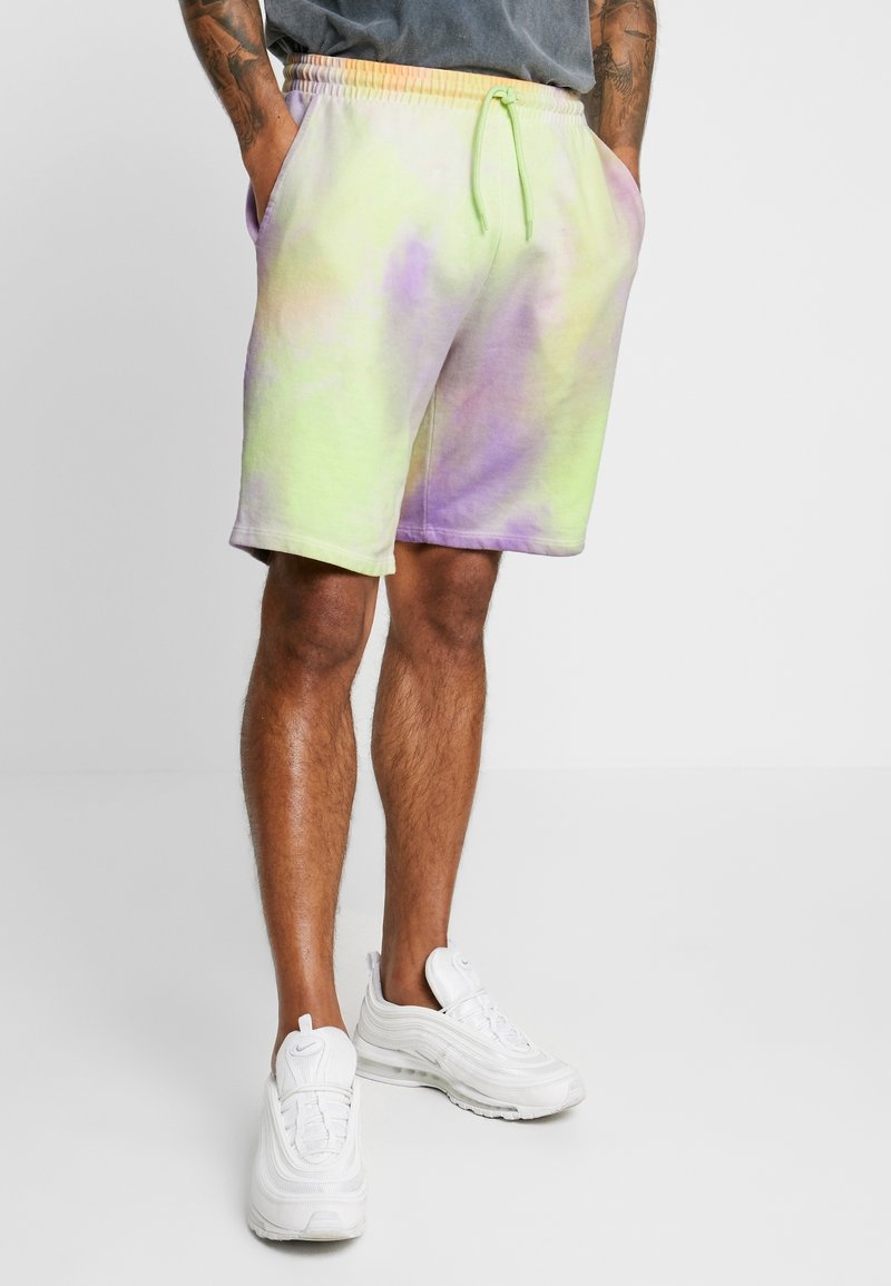 Shorts tie-dye dans des teintes vertes et lavande, fabriqués en coton doux avec une taille élastique et un cordon de serrage. Comprend des poches latérales.