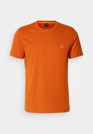 Kurzes T-Shirt aus leuchtend orangefarbenem Baumwollstoff. Verfügt über ein kleines quadratisches Logo auf der linken Brust und ein klassisches Rundhalsdesign.