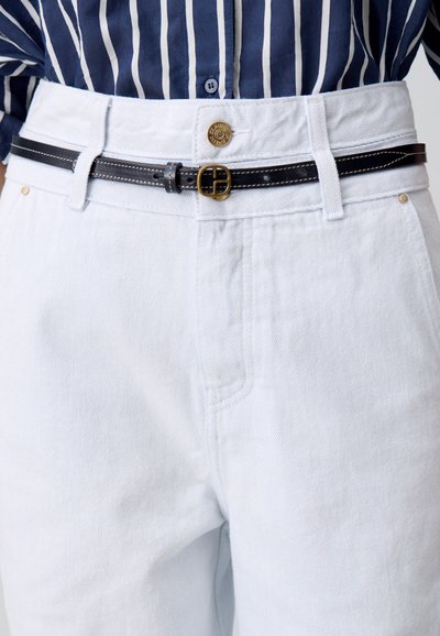 Pantalons en denim blanc à coupe décontractée, dotés d'une ceinture en cuir noir et d'une boucle dorée, présentés avec une chemise à rayures bleues et blanches.