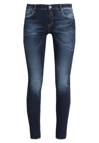 Jeans ajustados de mezclilla azul oscuro con una textura suave, diseño de cinco bolsillos y sutiles detalles de desgaste en la parte delantera y trasera. Cierre de botón metálico.