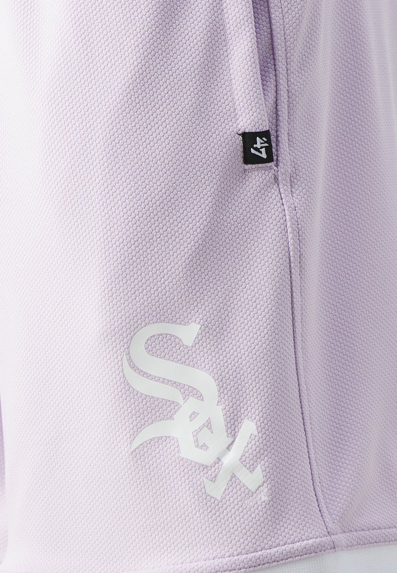 Shorts de sport violets en tissu texturé. Présentent un logo blanc et une étiquette de marque noire sur le côté. Design décontracté avec poches.