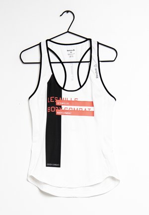 Biała i czarna sportowa koszulka bez rękawów marki Reebok z napisem „Les Mills Bodycombat” wisząca na czarnym wieszaku.