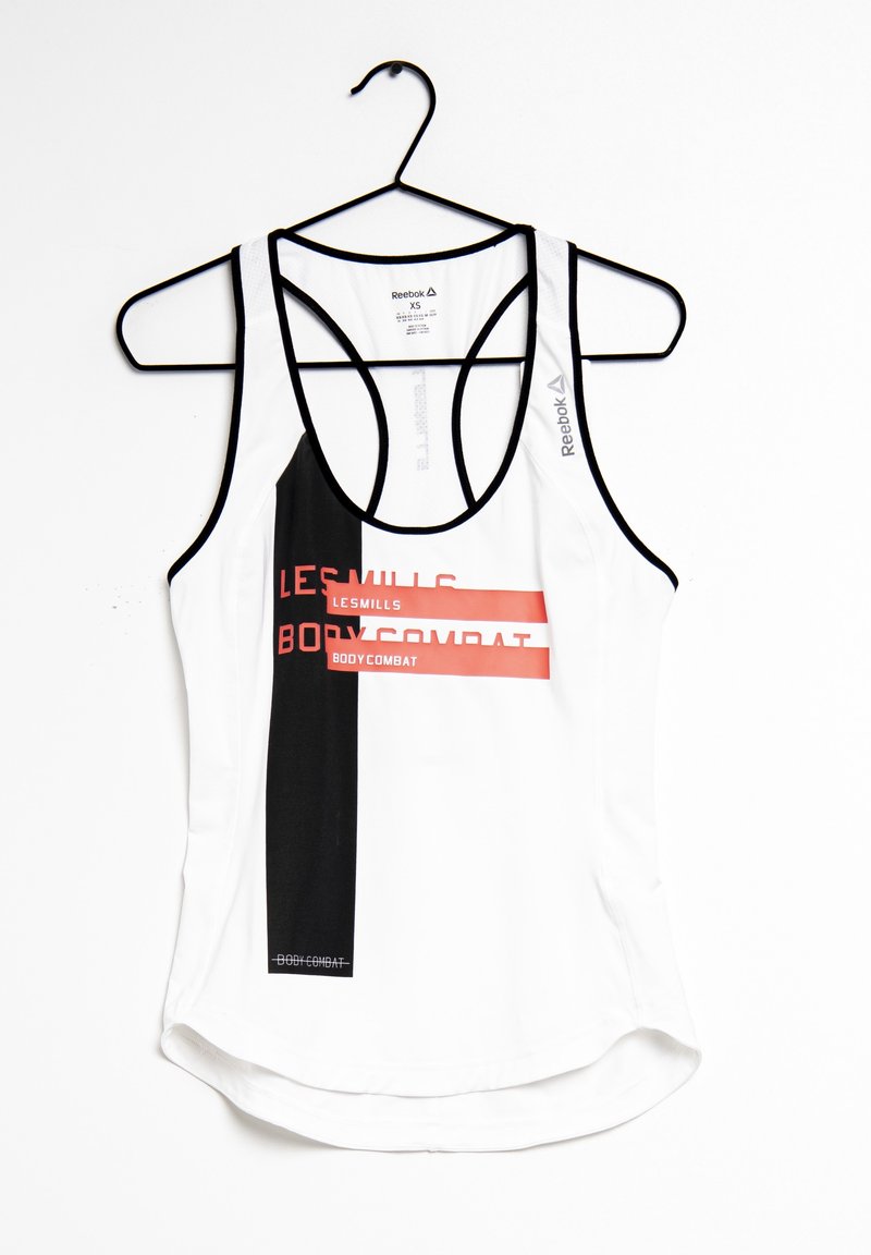 Débardeur de sport blanc et noir Reebok avec le texte « Les Mills Bodycombat » suspendu sur un cintre noir.
