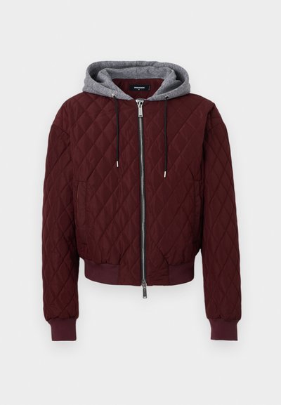 Veste zippée matelassée bordeaux avec poignets et ourlet côtelés, dotée d'une capuche grise amovible avec cordons de serrage.