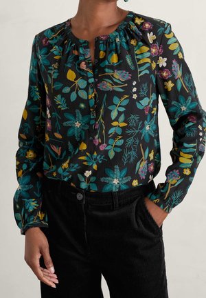 Bluse med blomsterprint i sort med farverige mønstre, med rund halsudskæring, knapdetaljer og lange ærmer. Tekstureret stof.