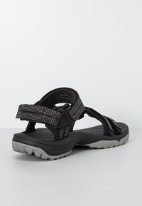 Czarne sandały z teksturowanymi paskami z wielokolorowymi akcentami. Grube szare gumowe podeszwy z bieżnikiem zapewniającym przyczepność.