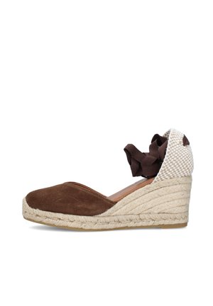 Espadrilla con zeppa in camoscio marrone con cappuccio del tallone intrecciato e nastro da annodare alla caviglia, suola piattaforma avvolta in juta, vista laterale su sfondo bianco.