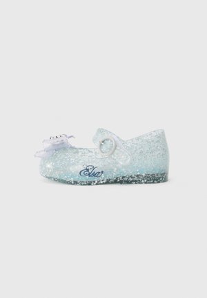 Light blue glittery shoe with a rounded toe, a strap with a round buckle, and a decorative bow. Features branding on the side.