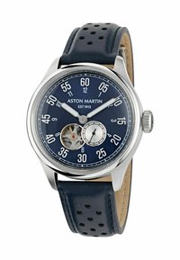 Un reloj de pulsera con caja de plata y correa de cuero perforado azul, esfera azul marino, números blancos, subesfera y movimiento mecánico visible.