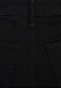 Svarta jeans i denim med en slät yta, horisontell sömnad och två bakfickor. Designen har en medelhög midja.