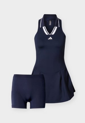 Vestido de tenis azul marino sin mangas con cuello a rayas blancas y pantalones cortos ajustados a juego debajo.