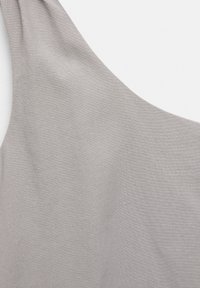 Vaaleanharmaa kangas, jossa on sileä pinta, yksineulontakuosisella ja pehmeällä laskostuksella, esittelee minimalistista estetiikkaa.