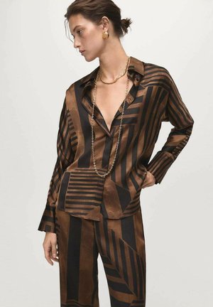 Set di camicia e pantaloni in satin marrone e nero con motivi geometrici. Caratterizzato da una vestibilità rilassata, colletto e maniche lunghe con chiusure a bottone.
