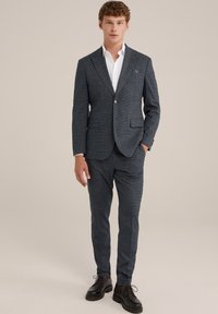 Mörkblå rutig kostym för män med en välsittande jacka och smala byxor, parat med en vit skjorta och svarta skor. Anmärkningsvärd fickruta.