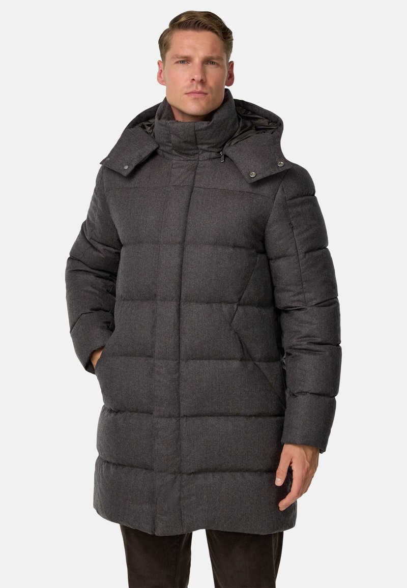 Pelēks pufīgs mētelis ar augstu apkakli un noņemamu kapuci. Iezīmējas ar kviltota dizaina, sānu kabatām un pogām ap kaklu.