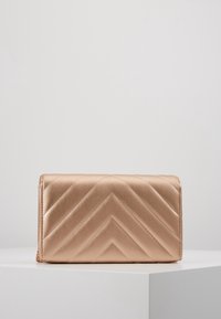 Roséguld clutchväska med ett chevronmönster, slät yta, dragkedjestängning och kedjeaxelrem. Den har en rektangulär form och är kompakt i storlek.