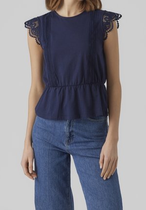Granatowa bluzka peplum z miękkiej bawełny, z koronkowym wykończeniem przy rękawach oraz pionowym detalem na przodzie, tworzącym efekt tekstury.