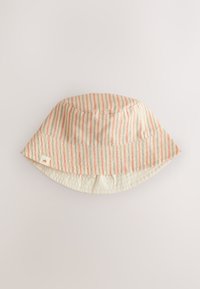 Bob rayé en tissu doux, présentant des lignes verticales en pêche et crème. Le bord est large, avec une petite étiquette de logo discrète sur le côté.