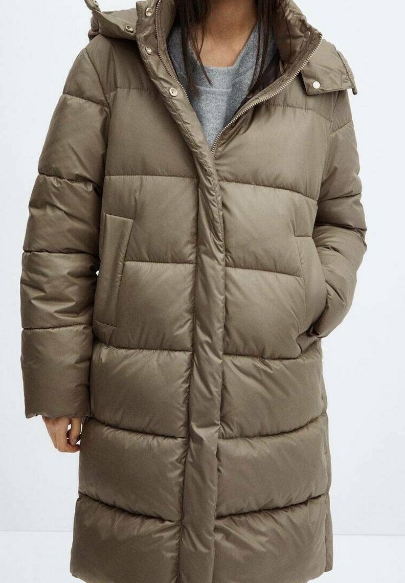 Manteau matelassé vert olive avec fermeture éclair et boutons-pression, présentant des coutures horizontales, des poches latérales et une capuche. Texture lisse et rembourrée.